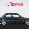Full side profile of the black BMW E30 325i Sport with MTech II kit