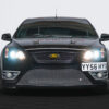 Front view of black Ford Focus ST3 with headlights on, yellow and black Ford badge, and aesthetic enhancements | Redline Competitions