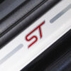 Close-up of silver ST-branded kickplate on black Ford Focus ST3 | Redline Competitions