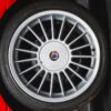BMW E30 M-tech II red close-up of Alpine badge on alloy wheel – Redline Competitions