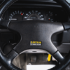 Close-up of steering wheel with dashboard dials 1993 Lotus Carlton UK car competition Redline Competitions
