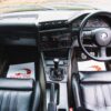 BMW E30 325i Sport interior with black leather M Sport seats and Alpine stereo available with Redline Competitions